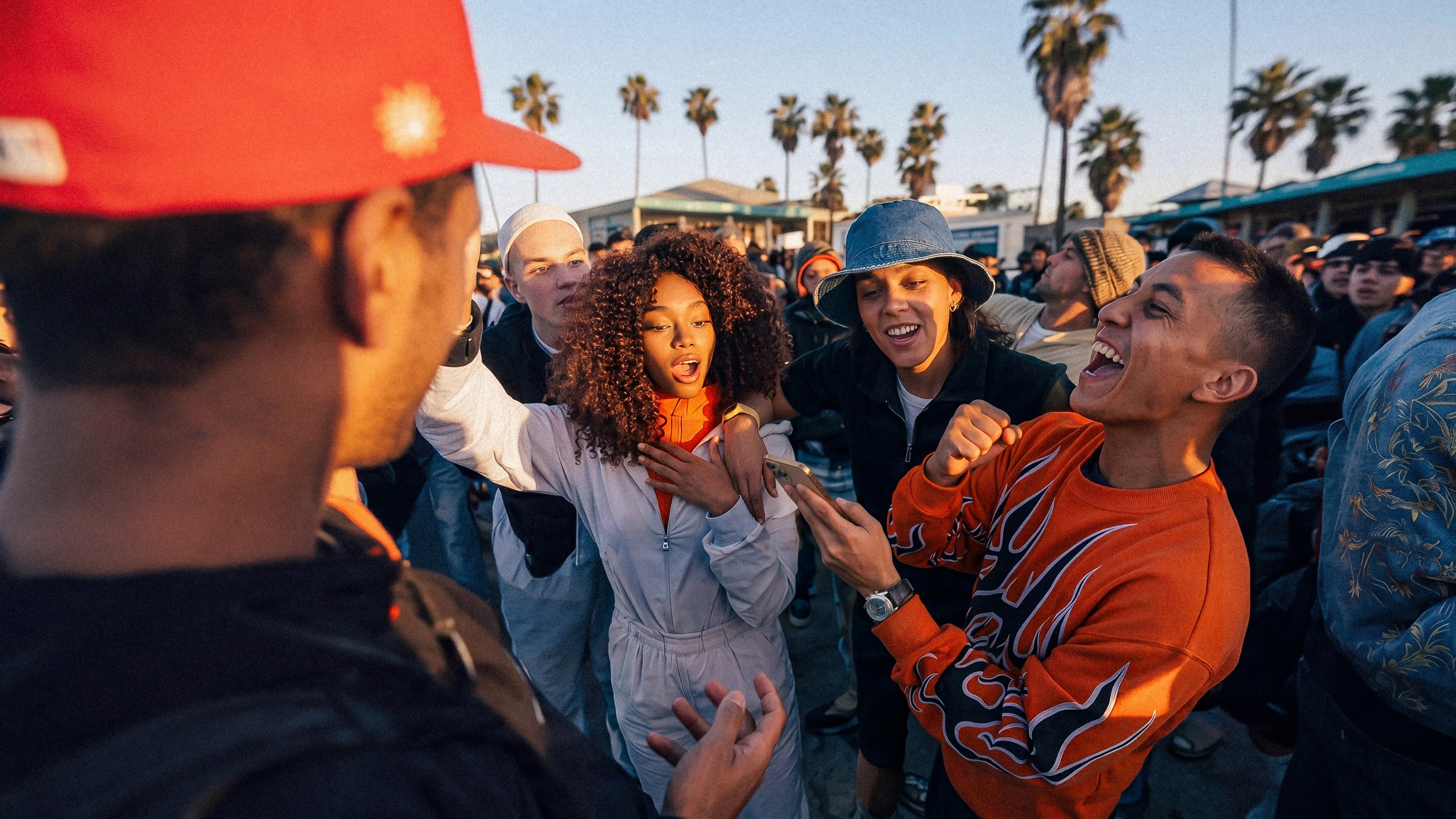 group of people looking at a smartphone and cheering