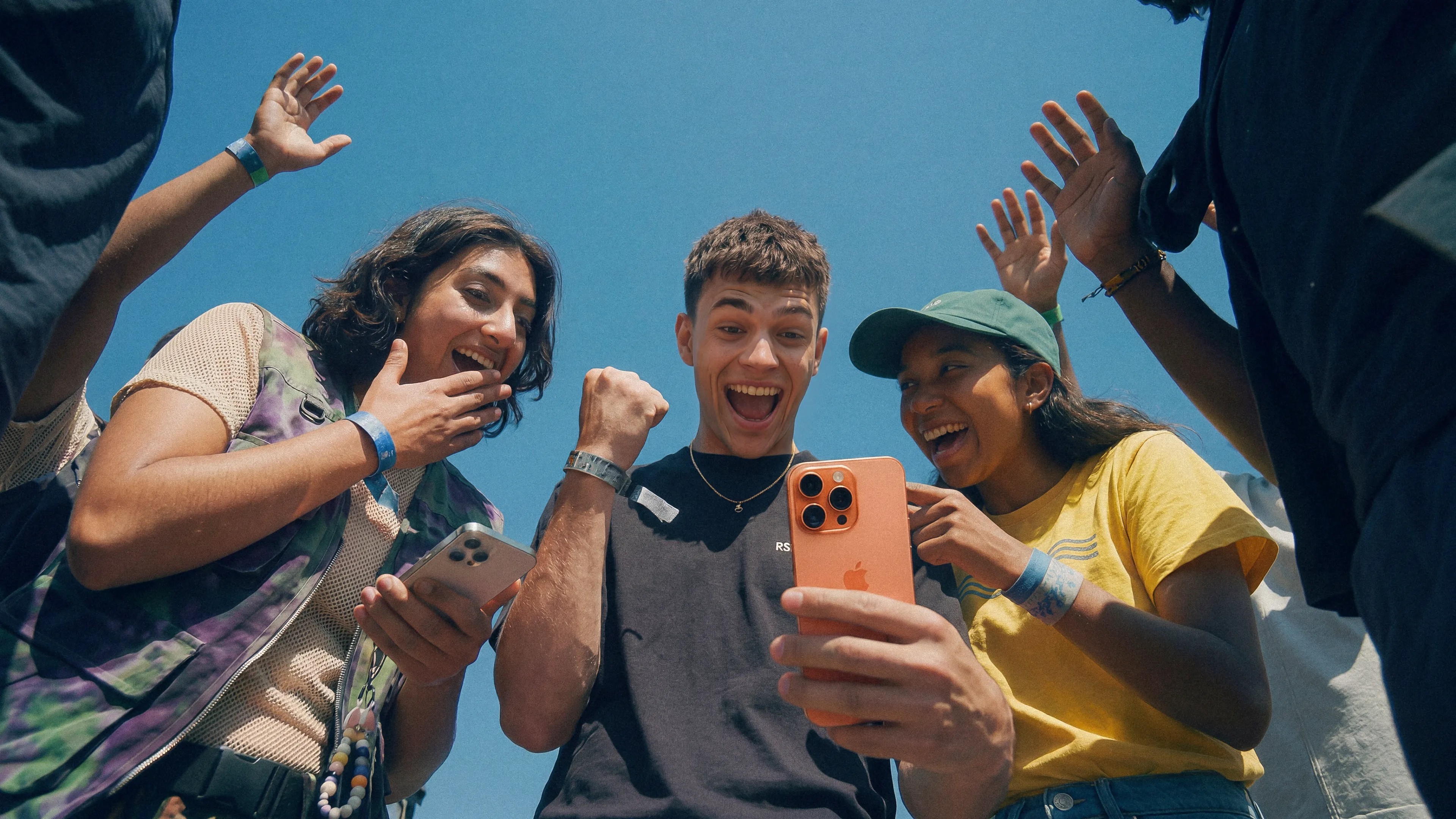 A group of young people are cheering to a mobile phone