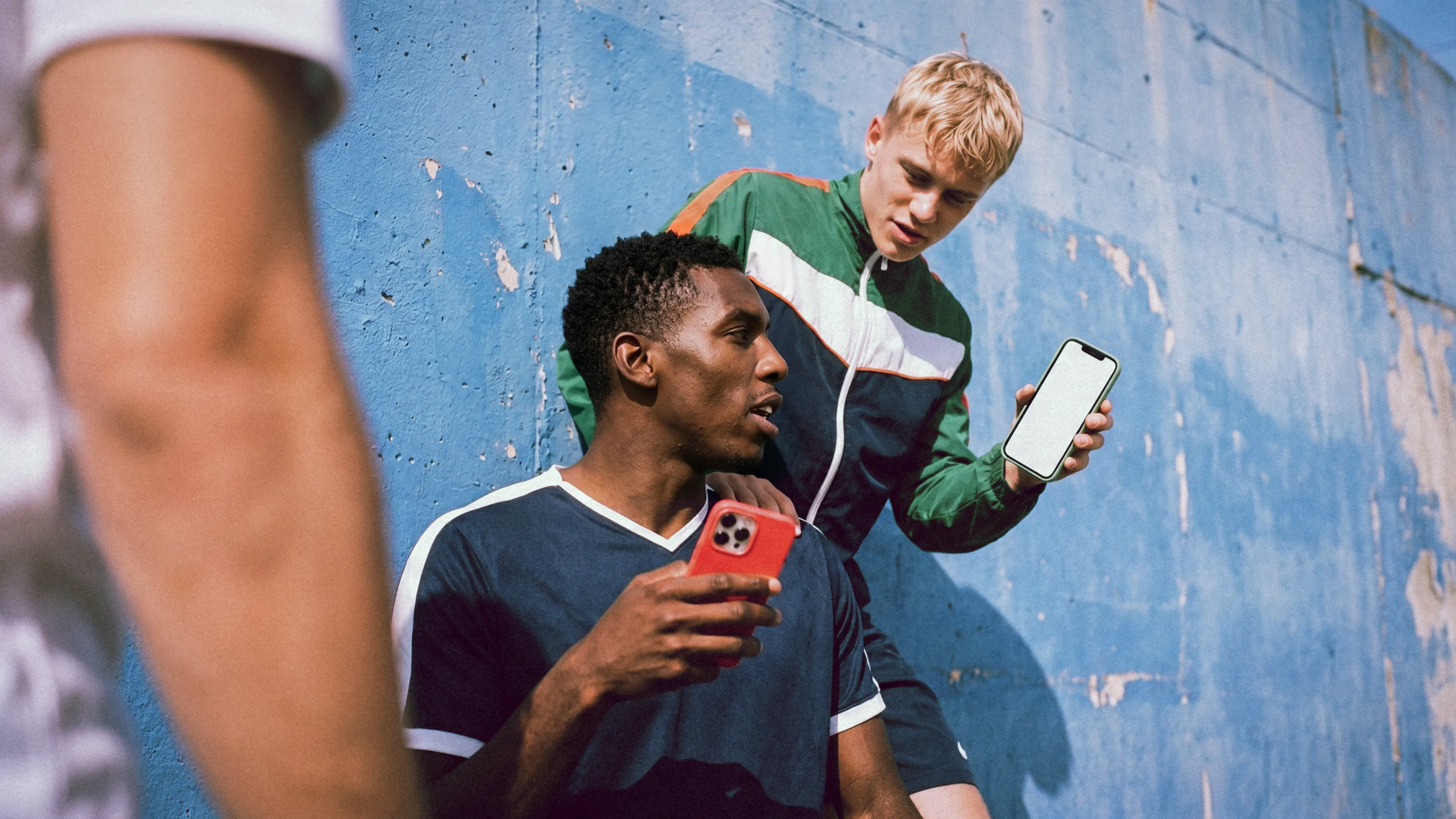 two men  one white and one black  showing each other something on their phones